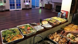 Un buffet proposant différents plats, un évier et une cheminée.