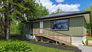 Une maison de plain-pied avec une terrasse en bois et une grande fenêtre.