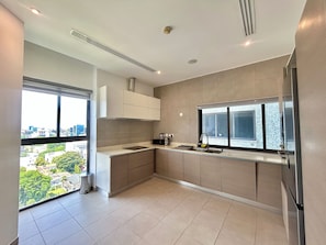 A modern kitchen with a large window, a built-in stove, and a sink. - Riverrun Residence (Lagos)
