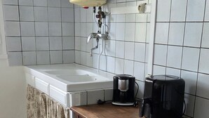 Eine Küche mit Spüle, Kaffeemaschine und Barhocker.