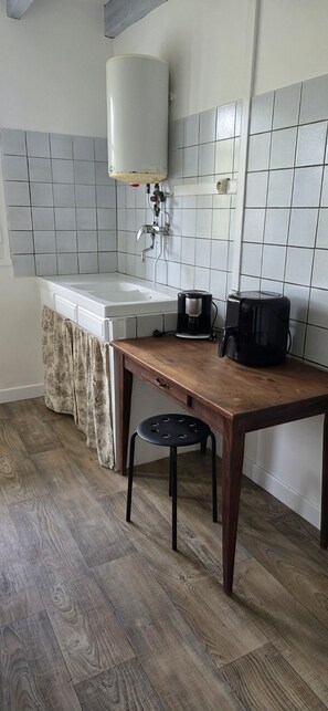 Eine Küche mit Spüle, Kaffeemaschine und Barhocker.