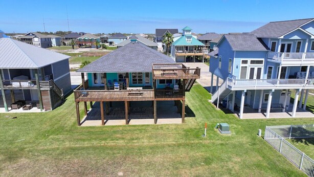 A coastal residential area with houses featuring balconies and a grassy lawn. - Waterview Home with Two Private Boat Lifts (Port O`Connor)