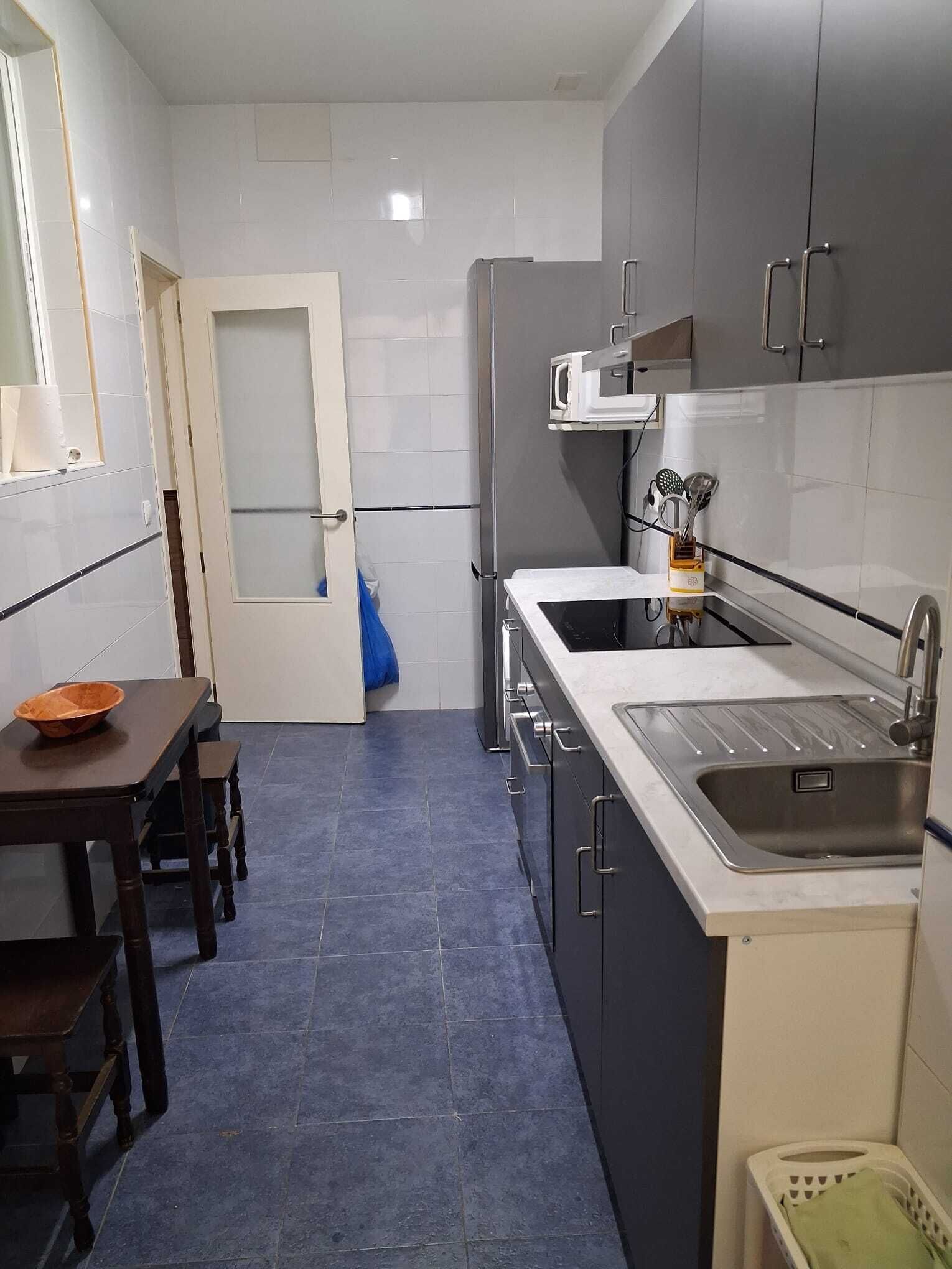 A compact kitchen with a sink, microwave, and cabinets.