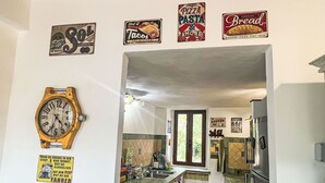 Eine Küche mit einer Uhr, einem Fenster und verschiedenen Schildern an der Wand.