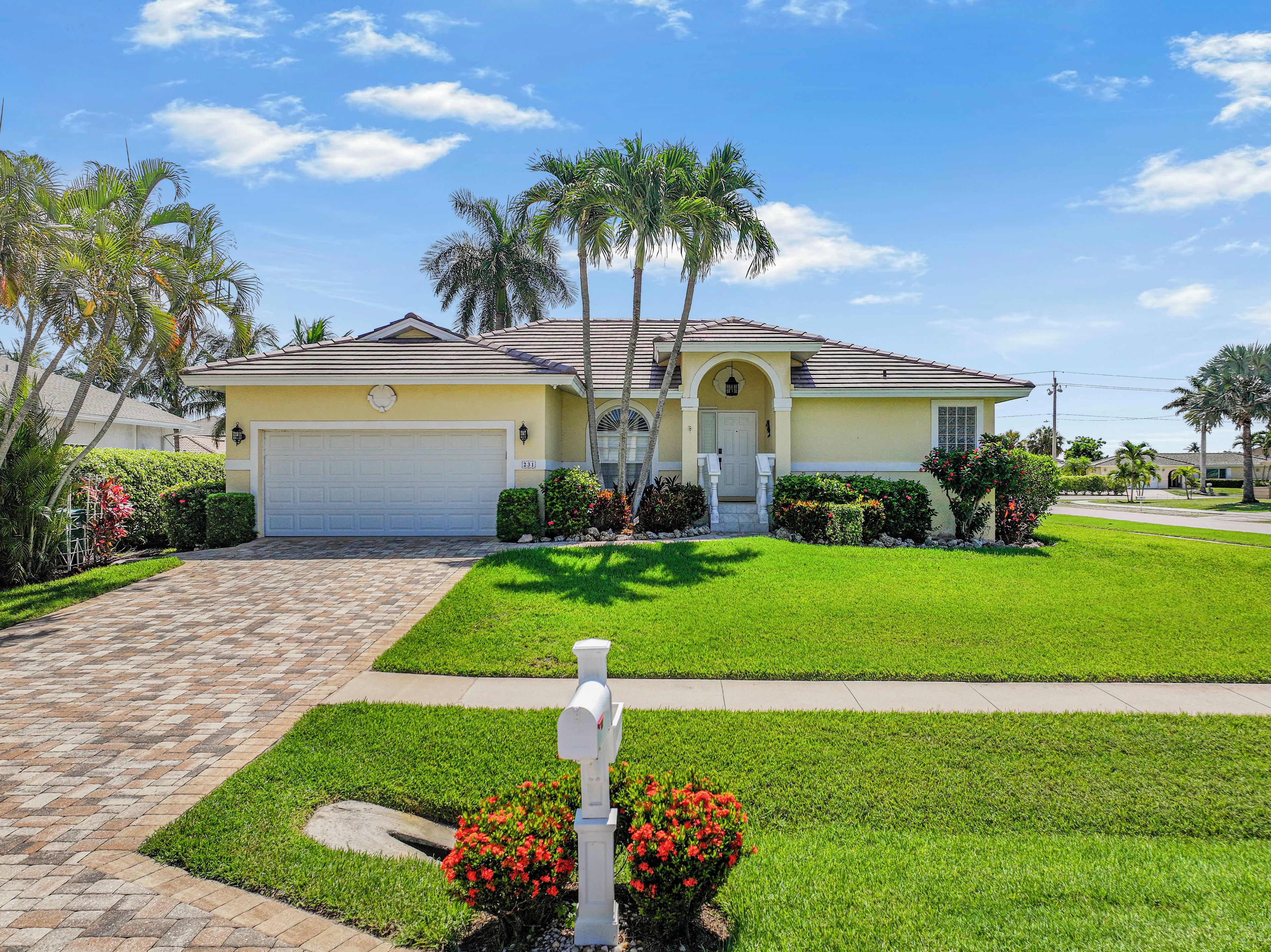 A residential house with a garage, a well-maintained lawn, and a mailbox.