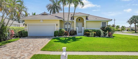 A residential house with a garage, a well-maintained lawn, and a mailbox.