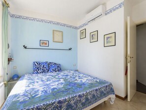 Un dormitori amb un llit, una porta i una paret amb quadres.