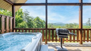 Un bain à remous sur une terrasse en bois, avec vue sur un paysage boisé.