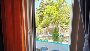 A room with a sliding glass door leading to an outdoor area with a small table and chairs. - Marina Fethiye Hanım Bodrum (Bodrum)