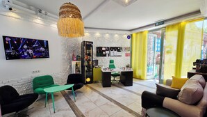 A hotel lobby with a TV, seating area, a bar, and a reception desk. - Marina Fethiye Hanım Bodrum (Bodrum)