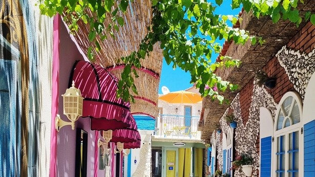 A narrow alley with colorful buildings, a reception area, and a clear sky. - Marina Fethiye Hanım Bodrum (Bodrum)