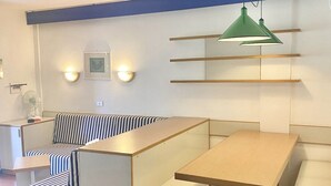 A modern room with a striped sofa, a wooden table, and a green pendant light. - P.Rotondo1 B106 S, two-room apartment with 5 beds (Porto Rotondo)