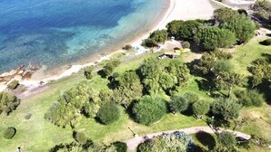 An aerial view of a coastal area with a beach, greenery, and a few structures. - P.Rotondo1 B106 S, two-room apartment with 5 beds (Porto Rotondo)