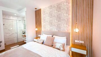 Una camera da letto moderna con un letto grande, una cabina doccia in vetro e un parete con texture.