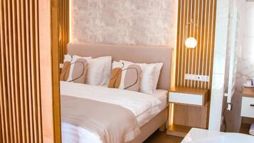 A modern bedroom with a bed, bedside table, and a wall-mounted light fixture.