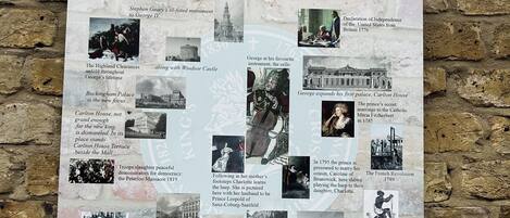 A historical information board with text and images detailing the history of a location, including notable events and figures.