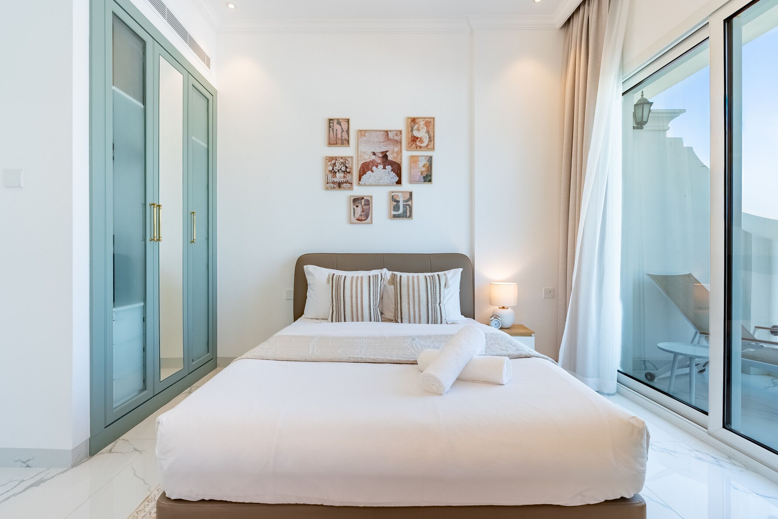 Habitación de hotel moderna con una cama grande, una puerta de vidrio y un balcón con vistas.