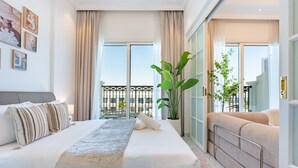 Ein Hotelzimmer mit einem großen Bett, einem Balkon mit Blick und einer Zimmerpflanze.