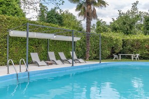 A swimming pool with a covered seating area and lounge chairs. - Cabañita rústica con piscinas cerca de A Coruña (Peiraio)