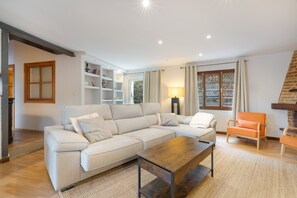 Ein Wohnzimmer mit Ecksofa, Couchtisch und Kamin.