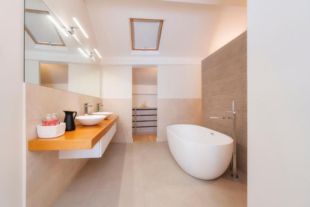 Een moderne badkamer met een vrijstaand bad, een wastafelmeubel en een spiegel.