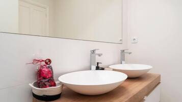 A bathroom with two white sinks, a mirror, and a towel rack.