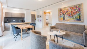 A modern living room with a sofa, coffee table, and dining area. - Bel Étage Binz - Stylish Suite with a Balcony (Binz)