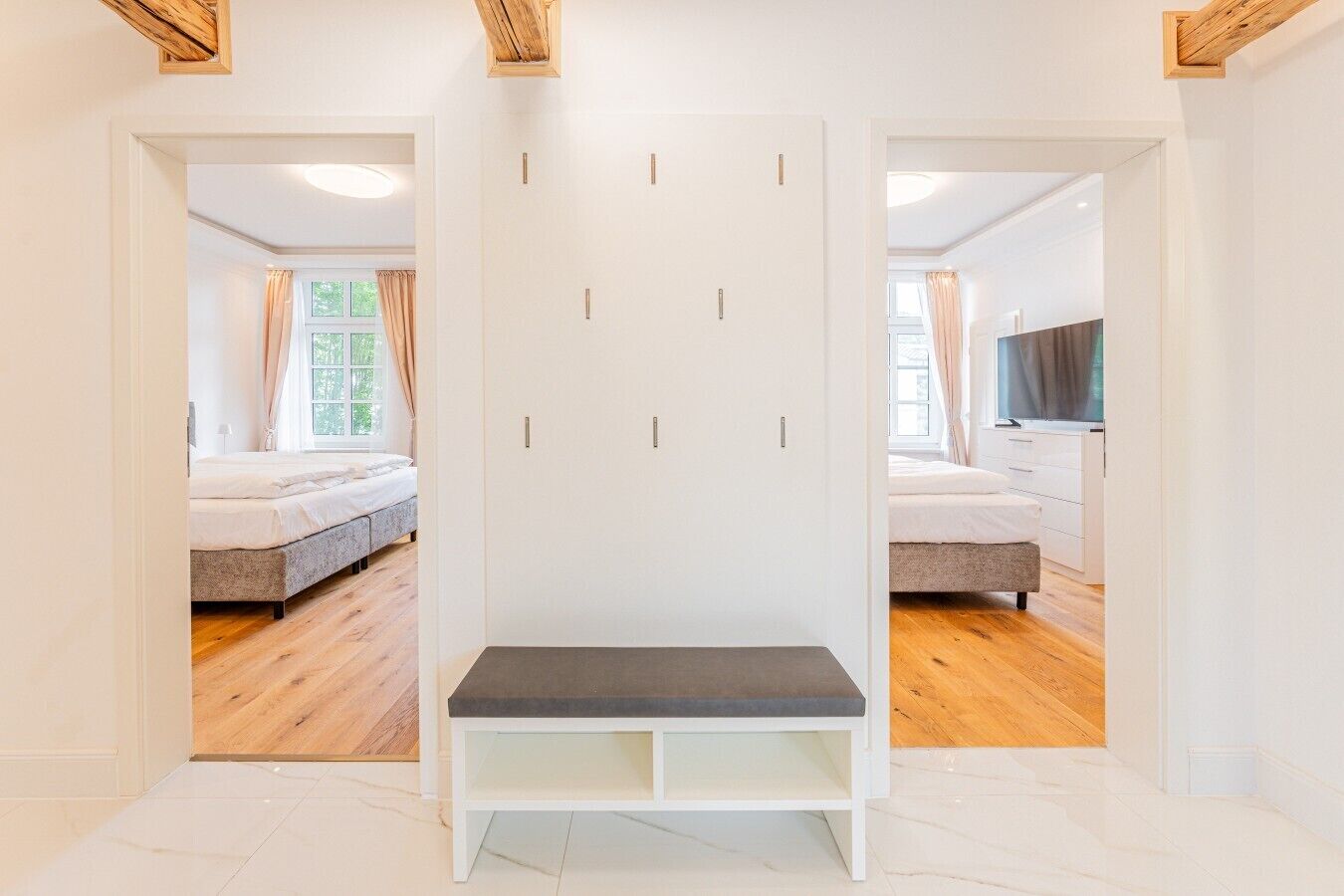 Una habitación con cama, un banco y un armario con varios compartimentos.