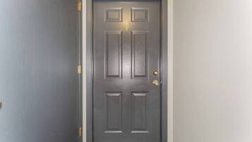 A closed dark wooden door with a brass doorknob and a brass handle on the right side.