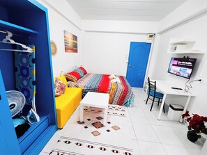A room with a bed, a desk, a chair, a TV, and a fan. - 203 Budget Room, Wifi&utilities, Bangkoks Center (Bangkok)
