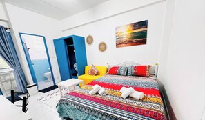 A bedroom with a bed, a small table, a chair, a bathroom with a toilet, and a door. - 203 Budget Room, Wifi&utilities, Bangkoks Center (Bangkok)