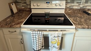 A kitchen with a white stove, a microwave above it, and a tiled backsplash.