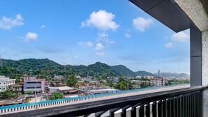 A balcony with a view of a cityscape, including buildings and a green hill in the distance. - Deluxe Cloud Stay (Guwahati)