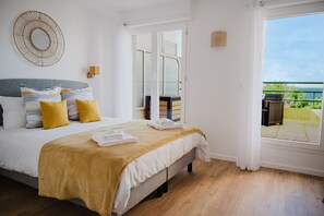 Une chambre à coucher avec un lit, une table de chevet, une fenêtre et une vue sur l’extérieur.