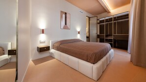 A modern bedroom with a large bed, bedside tables, a wardrobe, and a mirror. - Luxury designer suites just a short walk from the Spanish Steps (Roma)
