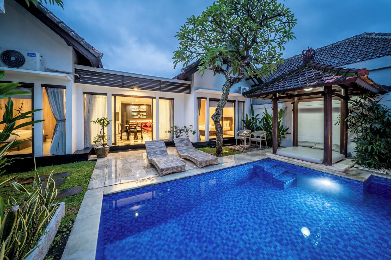 Uma casa moderna com piscina, área de estar coberta ao ar livre e um jardim bem cuidado.