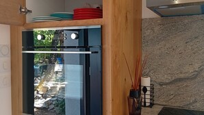 A kitchen with wooden cabinets, a built-in oven, a white refrigerator, and a marble countertop. - A little slice of paradise, nestled in the woods (Ste Baume, Canal de Provence, ... (Rougiers)