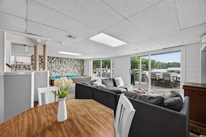 A modern interior with a pool table, a sofa set, and a dining area with a wooden table. - Lake Front Home, Huge fun dock & Hot Tub! (Sunrise Beach)