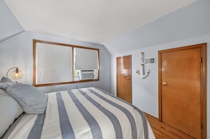 A bedroom with a bed, a window, a radiator, and a door. - Lake Front Home, Huge fun dock & Hot Tub! (Sunrise Beach)