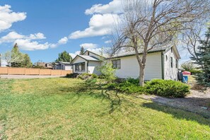 A row of single-story houses with a grassy yard and a wooden fence.