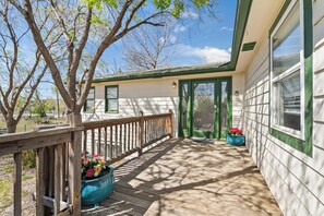 A wooden deck with a railing, a house with green trim, and a clear sky. - Light-Filled Lower Level with Private Entry on 2 Acres, Close to Shops (Arvada)