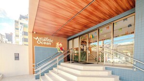 A hotel entrance with a wooden ceiling, blue tiled walls, and a sign reading 'Atlantic Ocean.' - Relax in an ocean view apartment in Barra (Salvador)