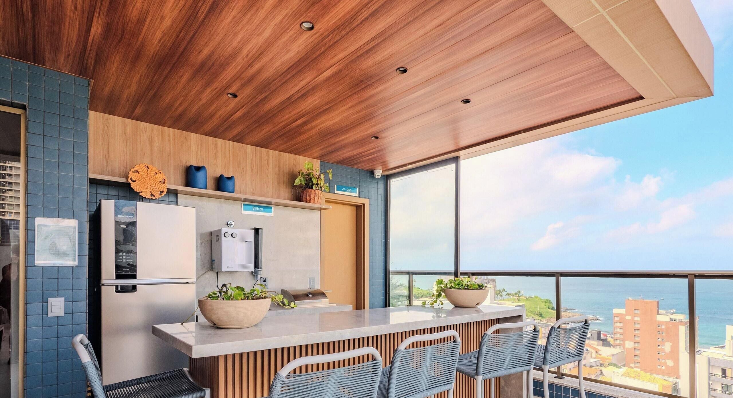 Una cocina moderna con techo de madera, estufa integrada y un amplio ventanal con vistas a la ciudad.