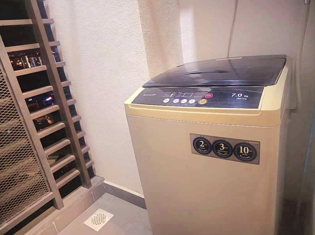 Una lavatrice compatta, color beige, da incasso con pannello digitale di controllo.