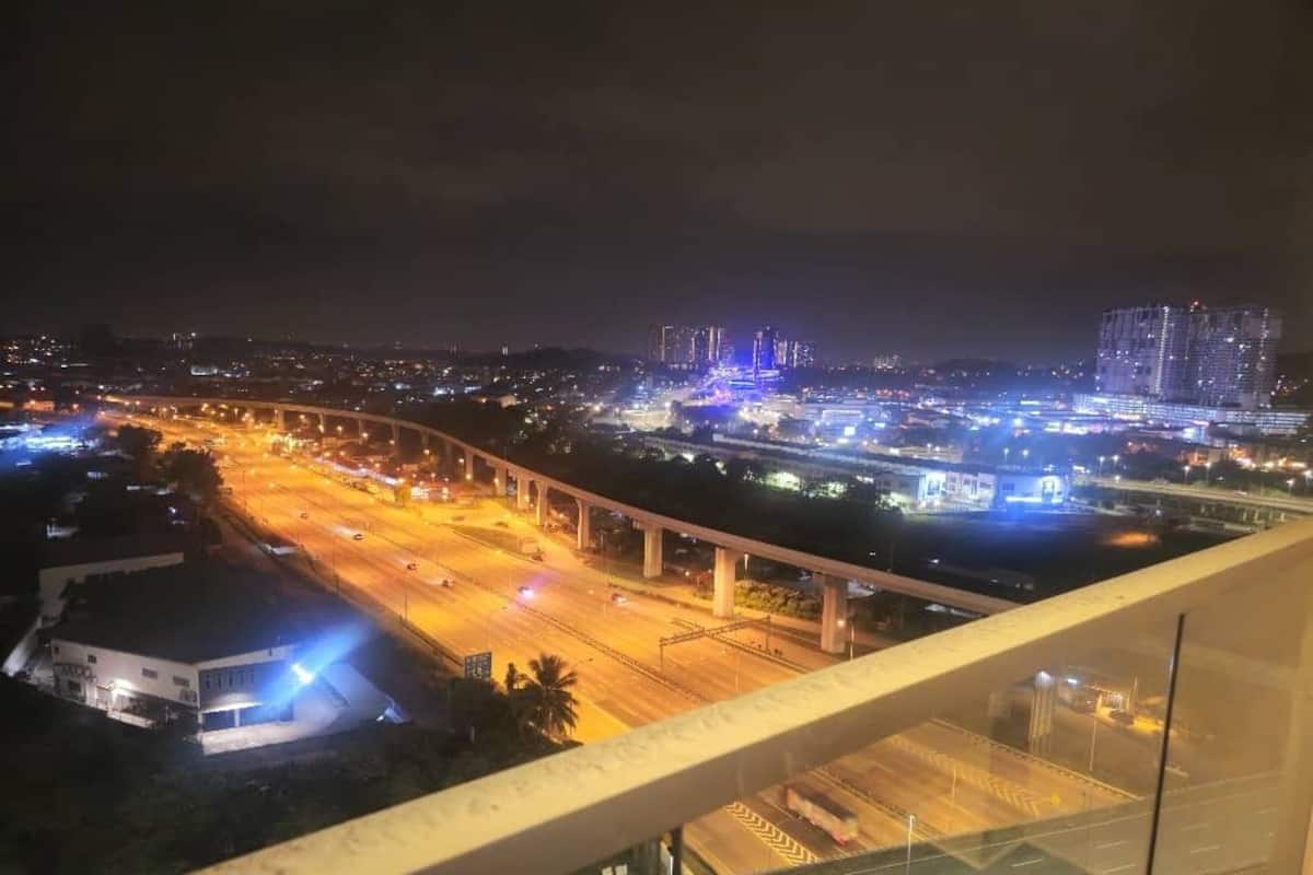 Paisagem urbana noturna com estradas, pontes e edifícios iluminados.