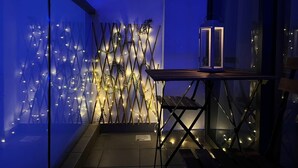 A room with a glass partition, a wooden table, and a decorative wall with string lights. - Landmark Residence I Kajang I City View (Kajang)