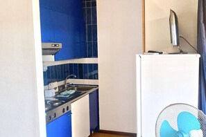 A compact kitchen with a stove, sink, and a white refrigerator. - P. Rotondo 1 I234 SEA VIEW Studio (Porto Rotondo)