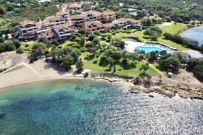 An aerial view of a coastal hotel with multiple buildings, a swimming pool, and a beach. - P. Rotondo 1 I234 SEA VIEW Studio (Porto Rotondo)