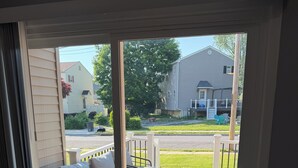 A room with a sliding glass door leading to an outdoor patio with a sofa and a small table.