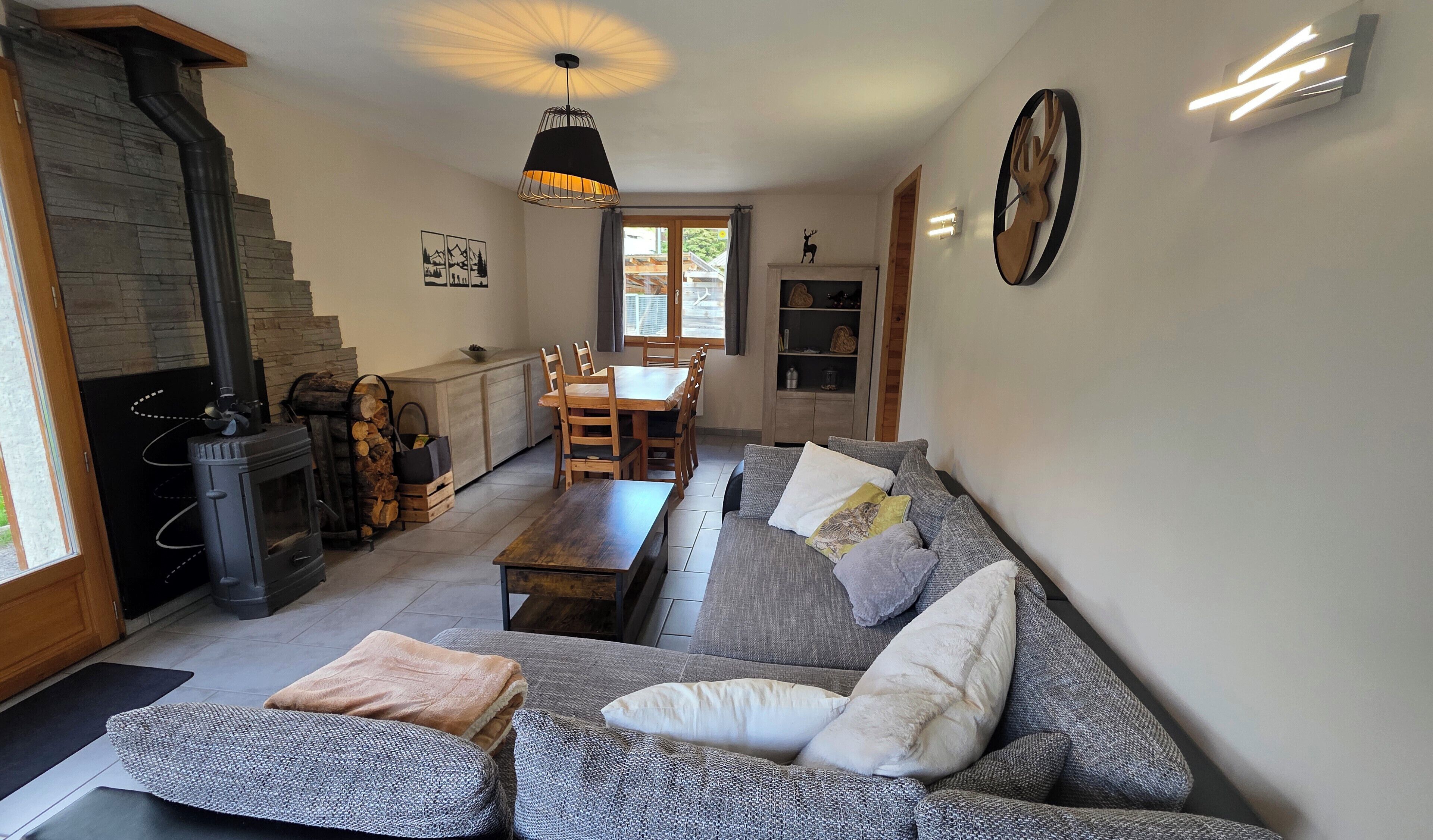 Een woonkamer met een bank, een open haard, een eethoek en een keuken.